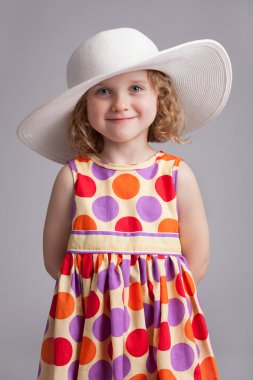 Beautiful little girl in a wide-brimmed hat clipart