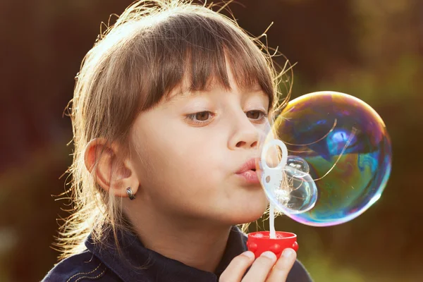 Klein meisje opgeblazen een grote zeepbel — Stockfoto