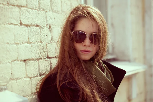 Модна модель в чорному пальто і сонцезахисні окуляри — стокове фото