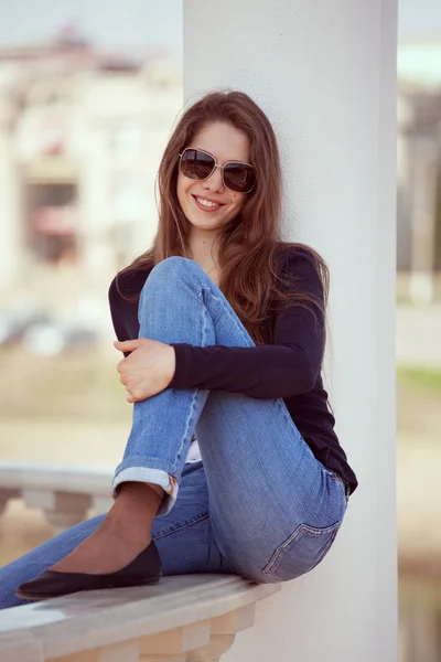 Mulher encantadora em óculos e jeans azuis — Fotografia de Stock