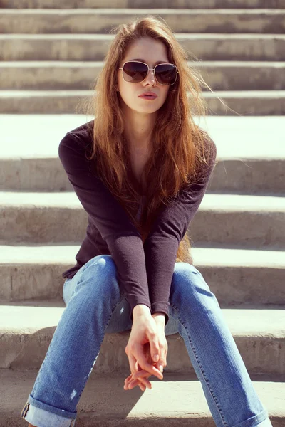 Femme en jeans assis et se reposant — Photo