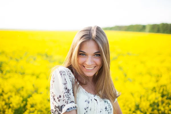 Sladká žena mezi žluté květy v létě — Stock fotografie