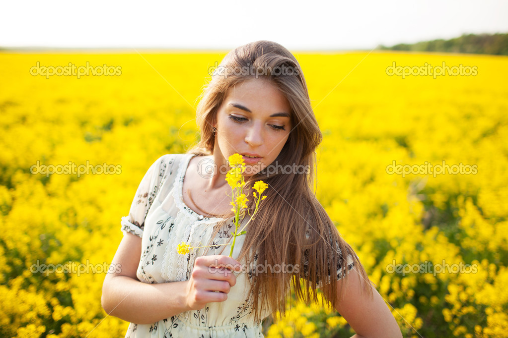 Pretty girl smelling yellow wildflower