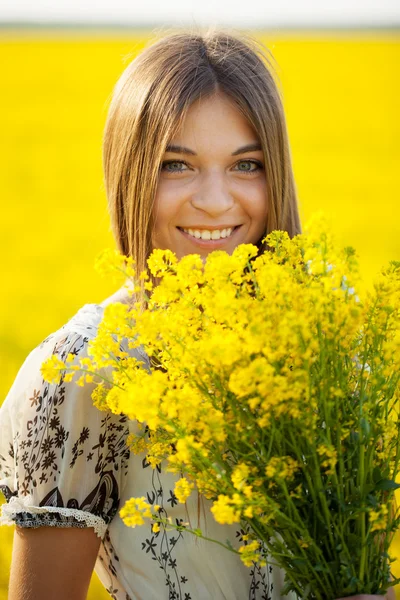 Flicka med en bukett av vilda blommor — Stockfoto