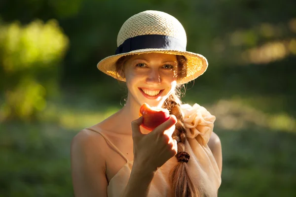 Mujer feliz en sombrero comiendo manzana —  Fotos de Stock