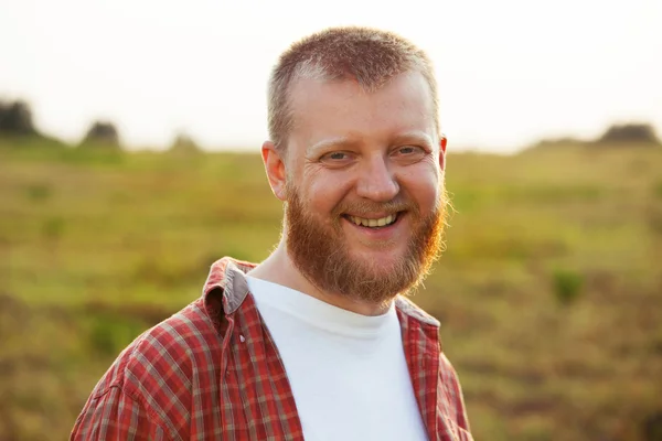 Vrolijke, bebaarde man in een rode shirt — Stockfoto