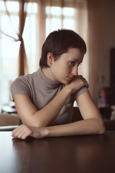 Triest vrouw zitten met handen geklemd — Stockfoto