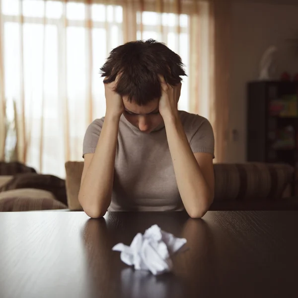 Crumpled letter lying on the table in front of a woman — Stock Photo, Image