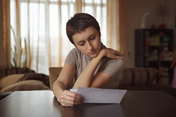 Mujer bonita leyendo una carta en la mesa —  Fotos de Stock