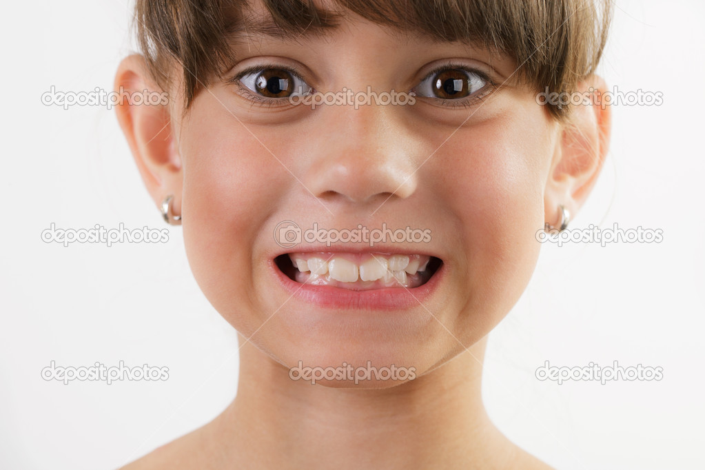 Cute cheerful little girl shows teeth