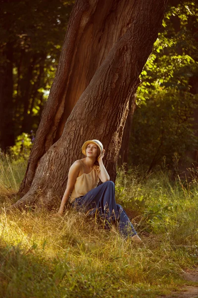 Romantikus, fiatal nő ül egy fa alatt — Stock Fotó