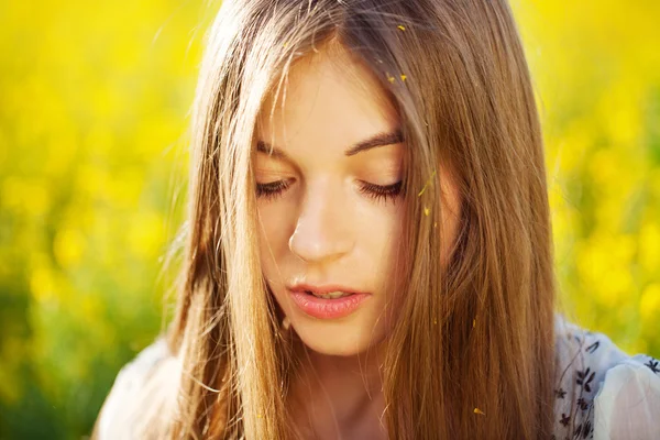 Hermosa chica con el pelo largo en flores amarillas — Foto de Stock