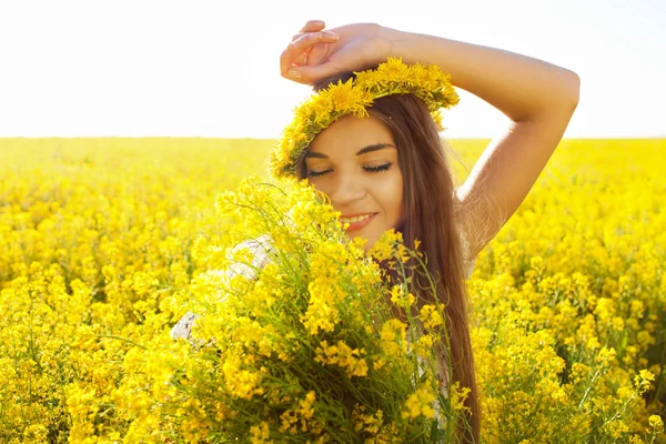 Счастливая девушка с букетом полевых цветов — стоковое фото