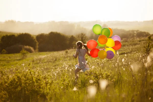 Happy little girl running across the field — Stock Photo, Image