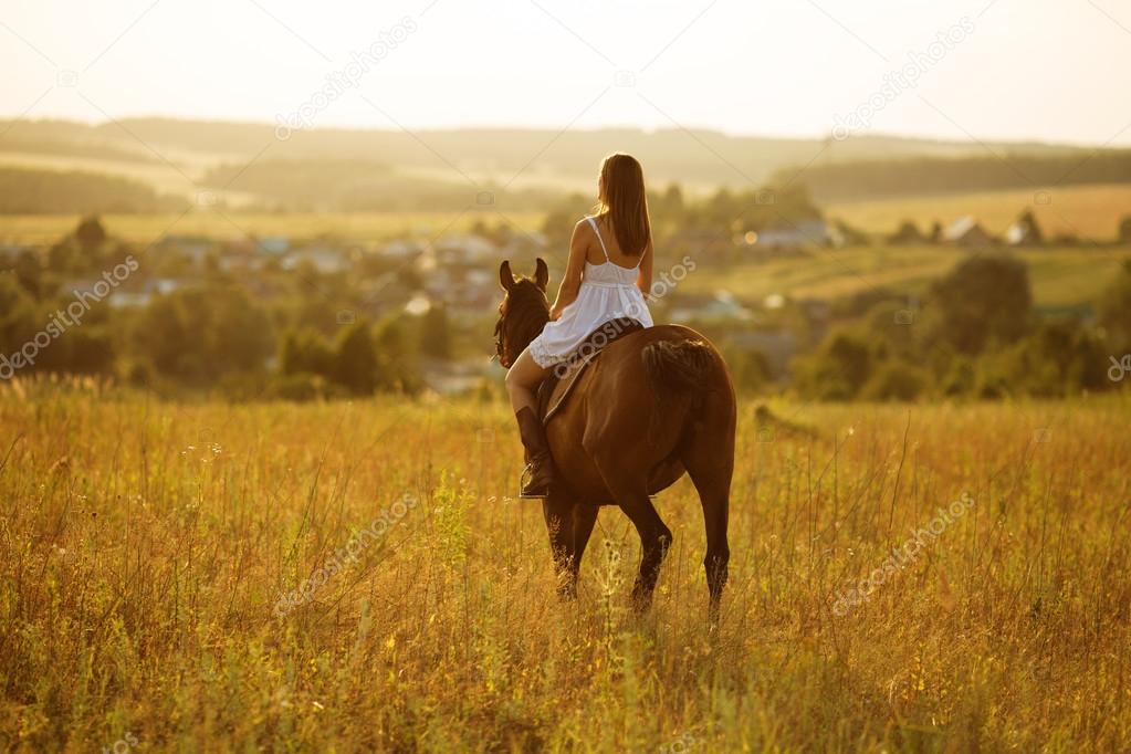 Girl in dress sitting on a horse