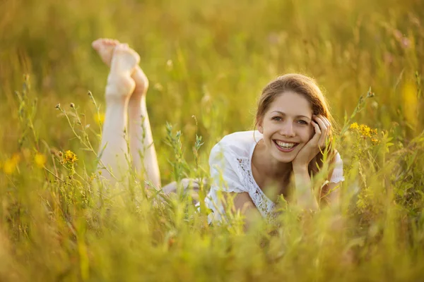 Menina feliz deitado na grama — Fotografia de Stock