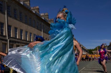 Bath, İngiltere, Birleşik Krallık - 9 Temmuz 2022: Somerset 'teki tarihi Bath kentinin caddelerinde ilerleyen geleneksel karnavalda süslü kostümlü dansçılar sahne alıyor.