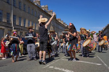 Bath, İngiltere, Birleşik Krallık - 9 Temmuz 2022: Somerset 'teki tarihi Bath kentinin caddelerinde ilerleyen yıllık karnaval davul grubu.