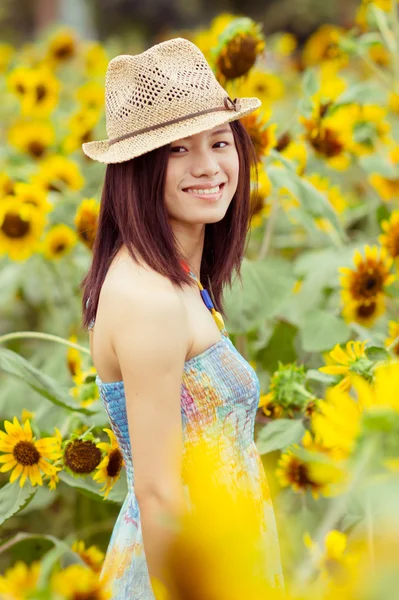 Ung asiatisk tjej i solros fält — Stockfoto