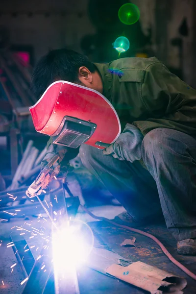 Trabalhador chinês soldagem metal — Fotografia de Stock