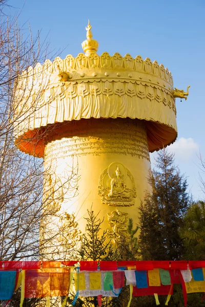 Буддийское молитвенное колесо и флаги — стоковое фото