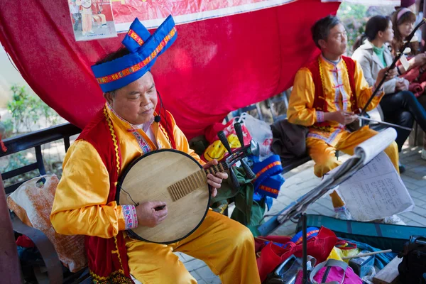 Китайский мужчина среднего возраста играет на музыкальном инструменте — стоковое фото