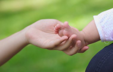 Anne elinde tutan küçük bebeğin ayak