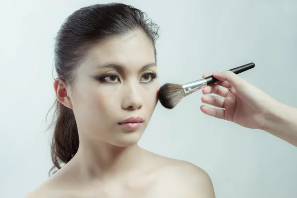 Chinese beauty applying makeup with brush — Stock Photo, Image