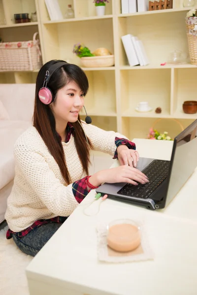Ung asiatisk kvinne som snakker med en bærbar datamaskin – stockfoto
