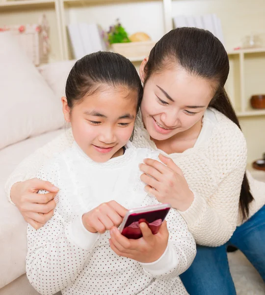 Madre e hija usando un teléfono inteligente — Foto de Stock