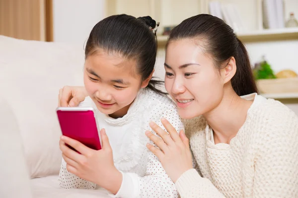 Madre e hija usando un teléfono inteligente — Foto de Stock