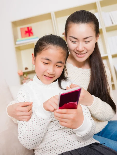 Madre e hija usando un teléfono inteligente — Foto de Stock