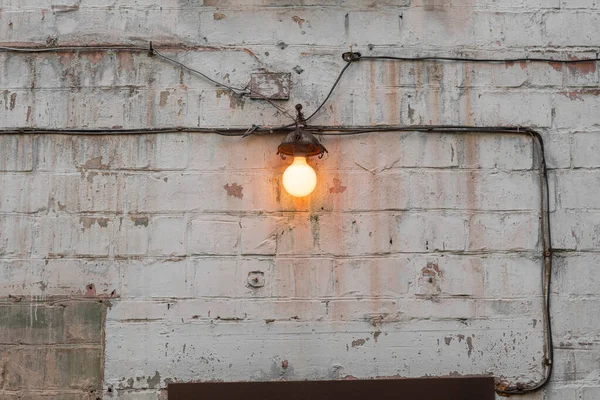 Warme Oranje Lamp Een Achtergrond Van Witte Oude Armoedige Bakstenen — Stockfoto