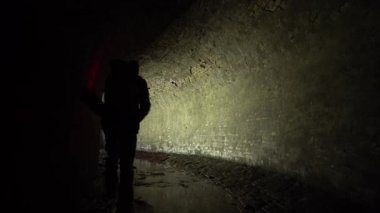 Kırmızı fenerli bir adam, 19. yüzyılın eski bir yeraltı su gideri toplayıcısına giriyor..