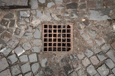 Old street rainwater drainage system of surface drainage system on cobblestone road. Uzhhorod, Transcarpathian oblast, Ukraine - Jan. 1, 2022