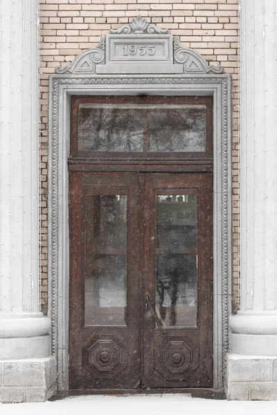 彫刻された装飾品と建物の入り口グループの正面の入り口の上に1955の碑文の扉 — ストック写真