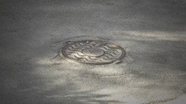 Top view of manhole sewer cover on asphalt.
