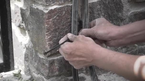 カップルによる固定と装飾的な石の壁に電源ケーブルの敷設 — ストック動画