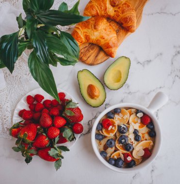 Kahvaltı, çilekli mini krep, kruvasan ve avokado nefis yaz yemekleri, mermer sırtlı üst manzara.