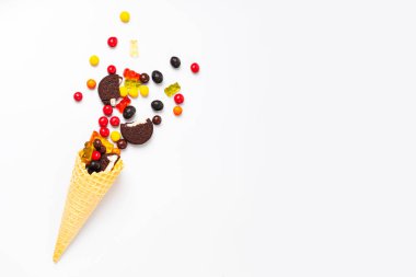 Beyaz arka planda şekerli, marmelatlı, kurabiyeli ve çikolatalı dondurma külahı.