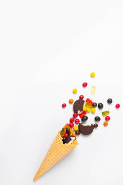 Beyaz arka planda şekerli, marmelatlı, kurabiyeli ve çikolatalı dondurma külahı.