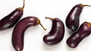 Beyaz zemin üzerinde su damlaları olan taze patlıcan.