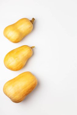 Beyaz arka planda üç taze balkabağı yatıyordu