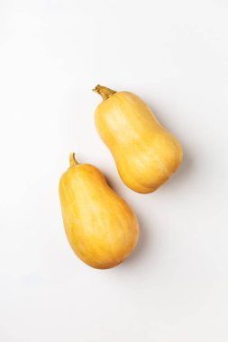 Beyaz arka planda iki taze balkabağı yatıyordu