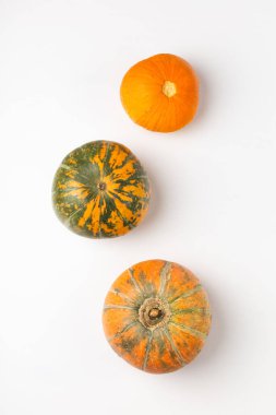 Beyaz arka planda üç olgun balkabağı