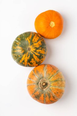 Beyaz arka planda üç olgun balkabağı