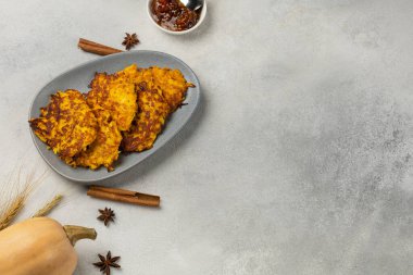 Balkabağı ve buğday dikenli hafif bir zemin üzerinde bir tabakta taze kabaklı gözleme.