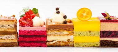 Beyaz arka planda çeşitli bisküvi meyveli kekler.