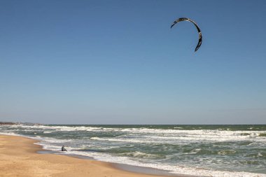 Su sporu. Uçurtma sürmek. Denizde uçurtma. Dalgalarda sörf yapmak. Dalgalarda sörf yap. Dalgıç kıyafetli bir sporcu. Olağanüstü bir hobi. Eğlence olsun diye sörf tahtası. Sudaki adam..