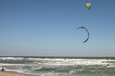 Su sporu. Uçurtma sürmek. Denizde uçurtma. Dalgalarda sörf yapmak. Dalgalarda sörf yap. Dalgıç kıyafetli bir sporcu. Olağanüstü bir hobi. Eğlence olsun diye sörf tahtası. Sudaki adam..